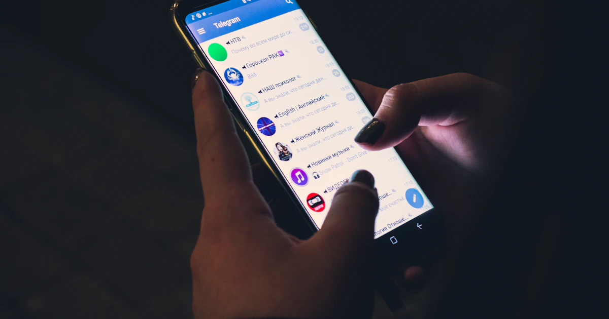Человек открывает Telegram на смартфоне — общение с клиентами в мессенджере